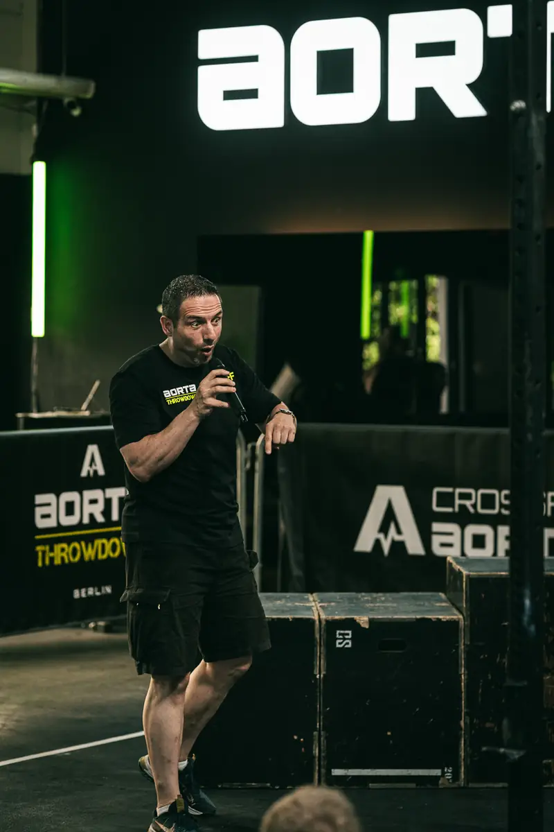 Moderator mit Mikrofon vor der Aorta-Wand beim Aorta Throwdown