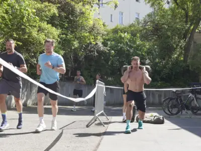 Sandbag Lunges und Läufer im Ziel bei der HYROX Simulation in Berlin