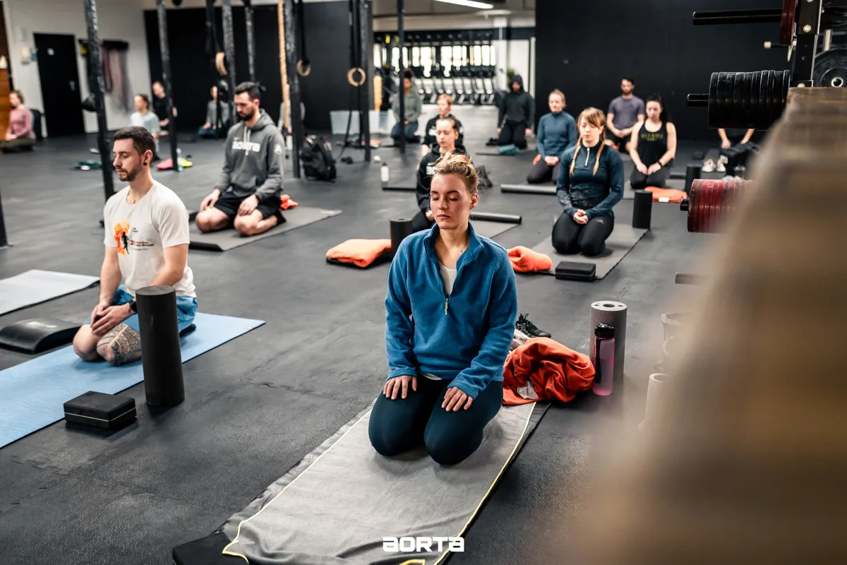 Yin Yoga Kurs im Hyrox & CrossFit Gym Aorta: Gruppe auf Matten mit Yoga Blöcken